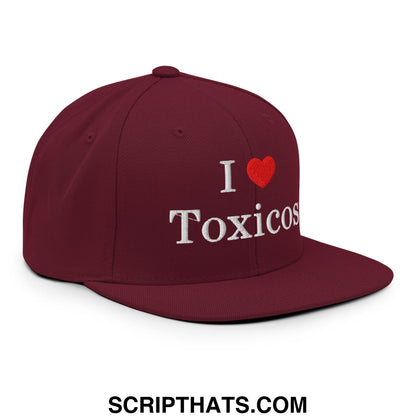 Maroon snapback cap with white embroidered i love toxicos text and red heart symbol on flat bill brim