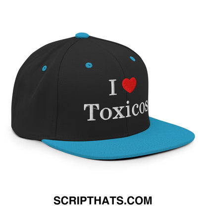 Black snapback hat with flat bill, blue brim and button, embroidered white i love toxicos text on front