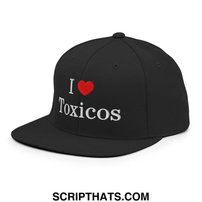 Black snapback cap with i love toxicos embroidered in white and red featuring a flat bill brim design