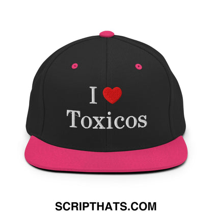 Black snapback cap with vibrant pink flat bill and button featuring white embroidered i love toxicos text on front