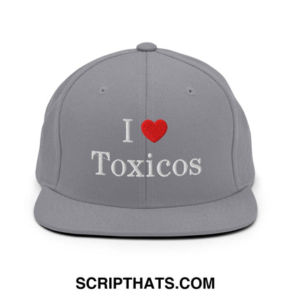 Gray snapback hat with white embroidered i heart toxicos text and red heart symbol on flat bill brim
