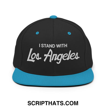 Black snapback cap with teal brim and button featuring white embroidered i stand with los angeles vintage script text