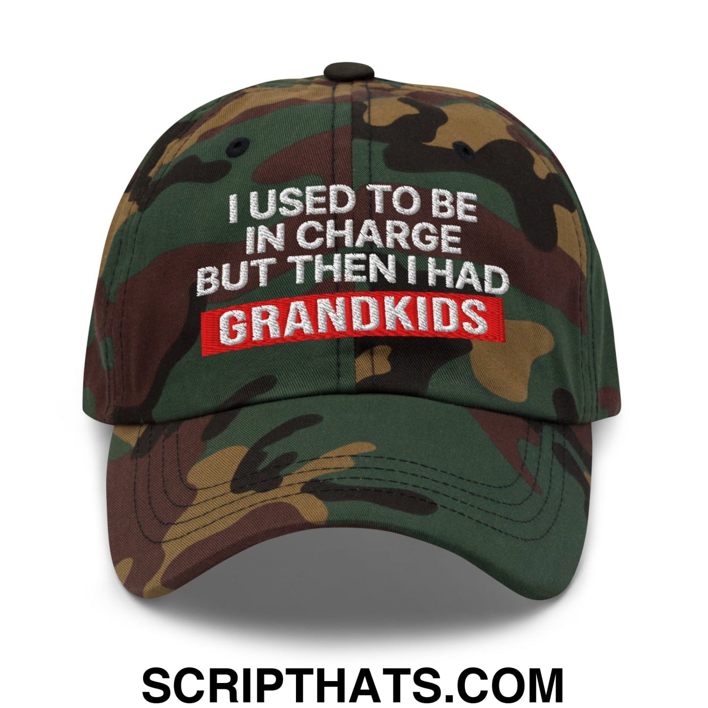 A camouflage embroidered unstructured dad hat with white text i used to be in charge but then i had grandkids on red background