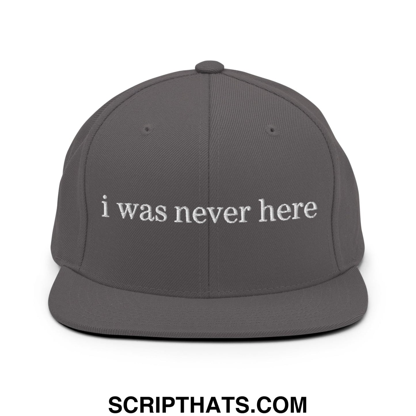 A dark gray snapback hat with white embroidered i was never here text and a flat bill brim design