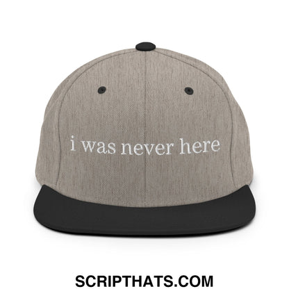 Gray and black snapback cap with a flat bill brim and white embroidered text reading i was never here