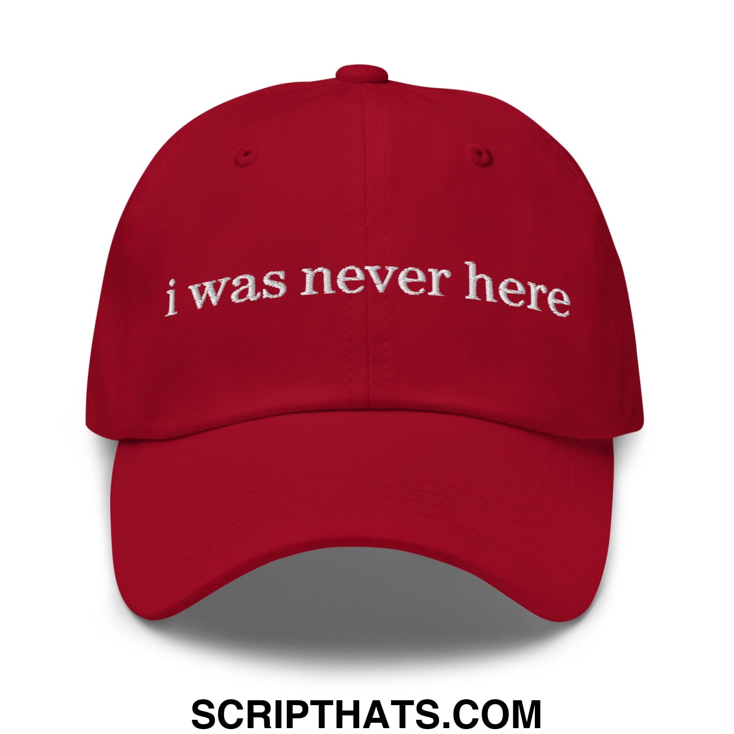 Red unstructured dad hat with white embroidered text i was never here on the front panel