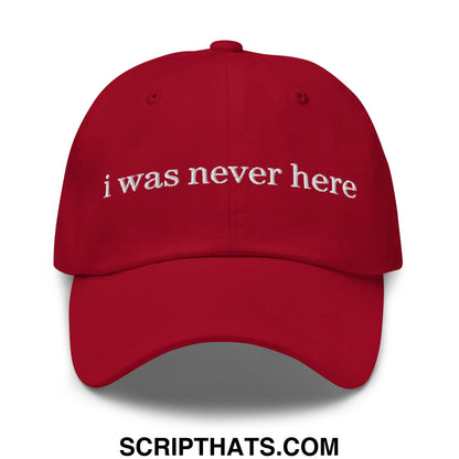 Red unstructured dad hat with white embroidered text i was never here on the front panel