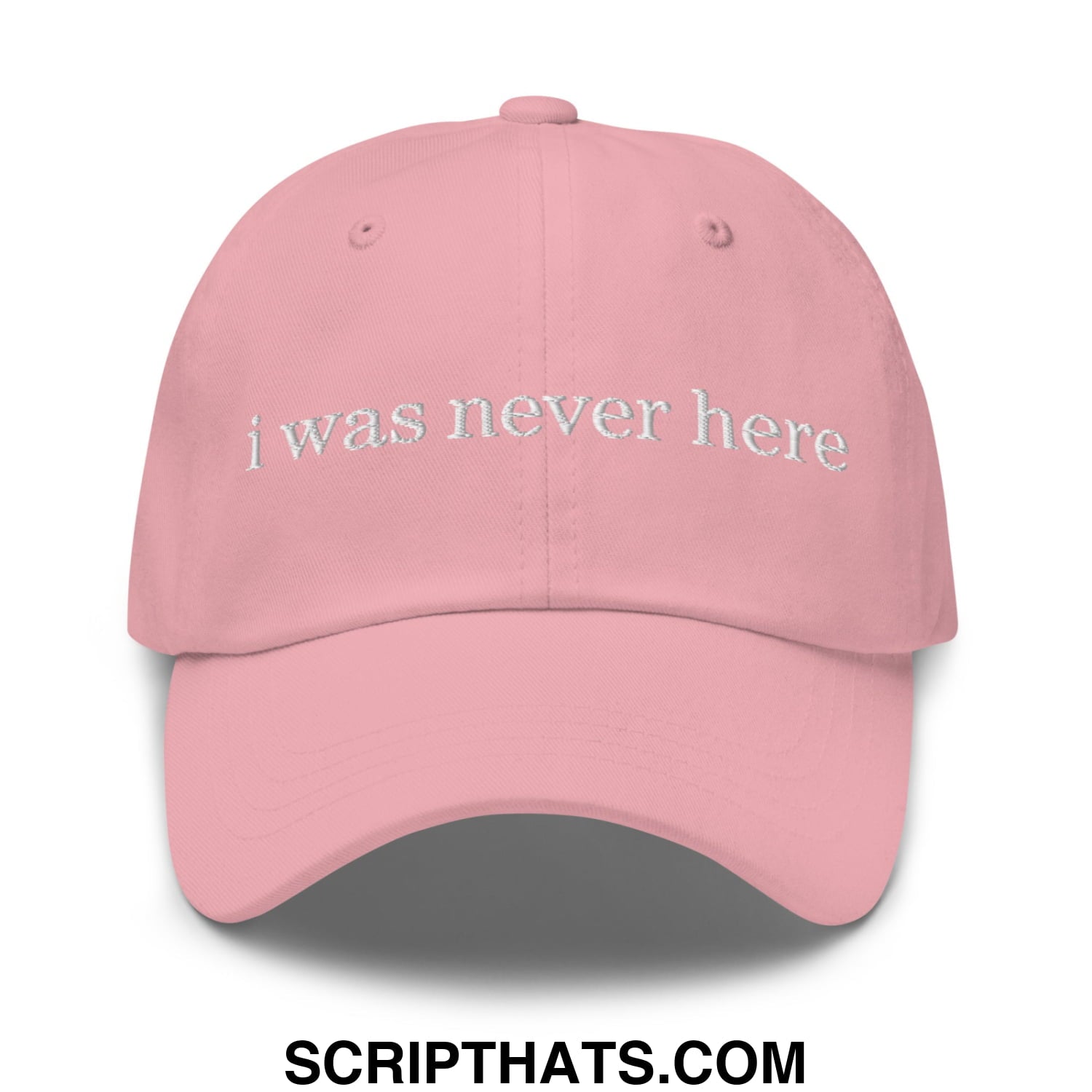 A soft pink unstructured dad hat with i was never here embroidered in white thread on the front