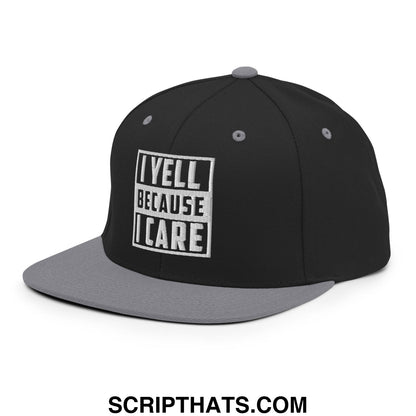 Black and gray snapback cap with white embroidered i yell because i care logo featuring a flat bill brim