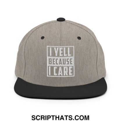 Gray and black snapback hat with white embroidered i yell because i care text inside a rectangular border