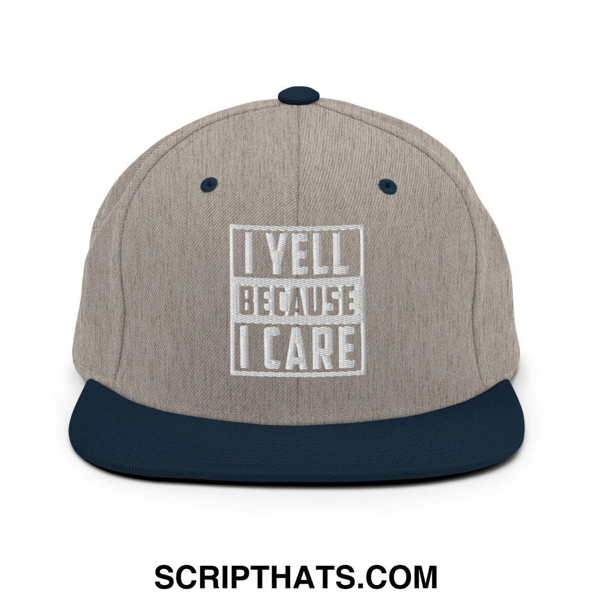 Beige and navy blue snapback hat with white embroidered i yell because i care text and rectangular border on flat bill brim