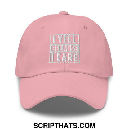 A soft pink unstructured dad hat with white embroidered i yell because i care phrase in a rectangular design