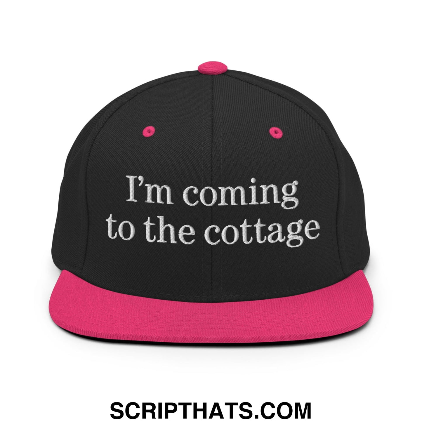 Black snapback hat with a vibrant pink brim and white embroidered im coming to the cottage text on the front