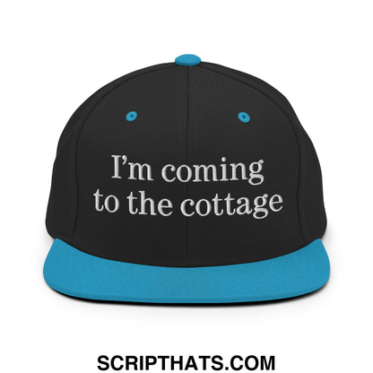 Black snapback cap with teal brim and button embroidered with im coming to the cottage text
