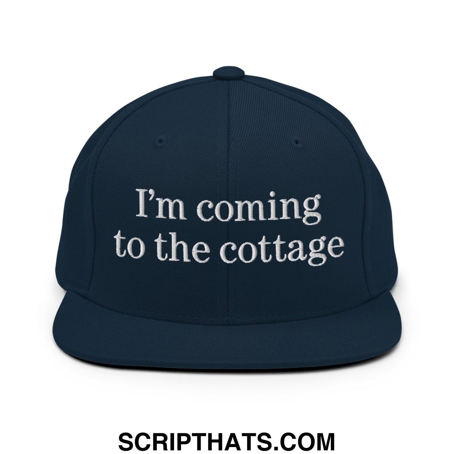 Navy blue snapback hat with white embroidered im coming to the cottage text and flat bill brim design