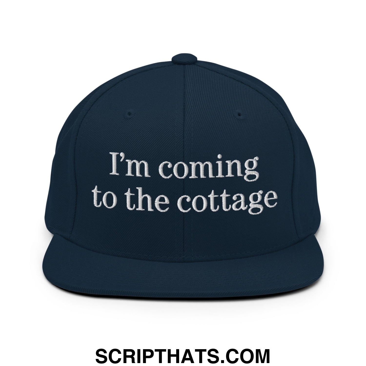 Navy blue snapback hat with white embroidered im coming to the cottage text and flat bill brim design