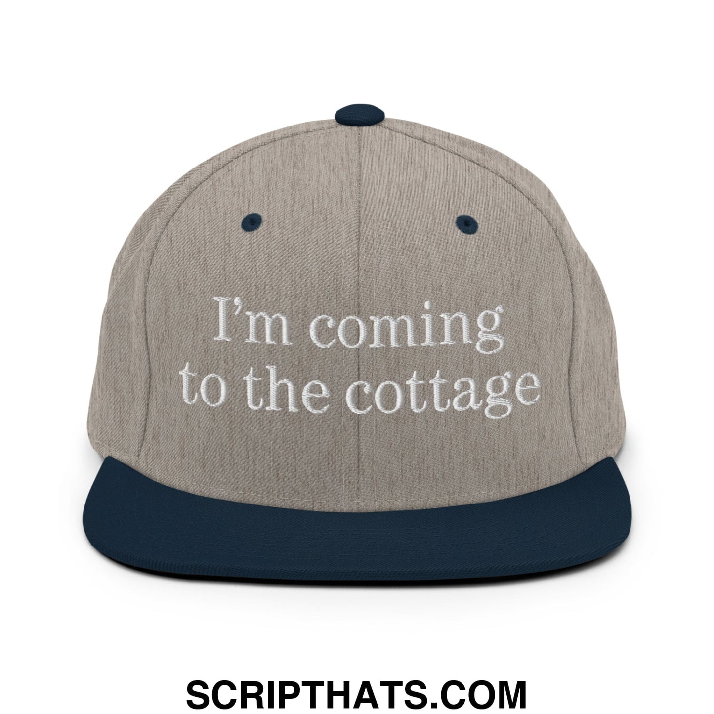 Beige and navy blue snapback hat with white embroidered text i’m coming to the cottage on flat bill brim