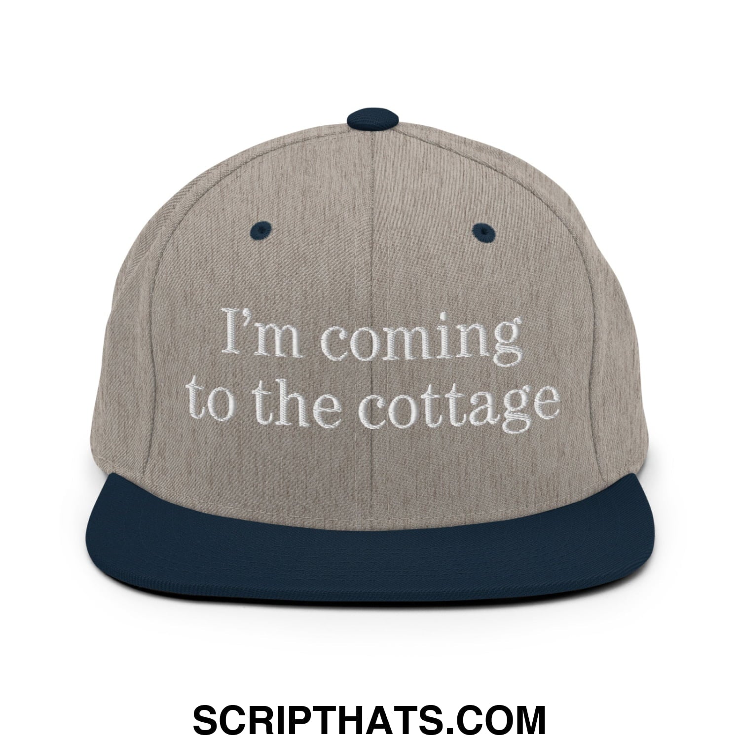 Beige and navy blue snapback hat with white embroidered text i’m coming to the cottage on flat bill brim