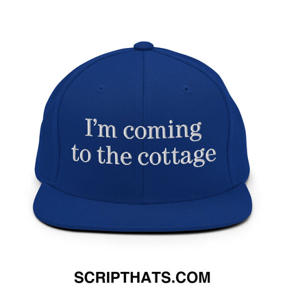 Royal blue snapback flat bill brim hat with white embroidered text I’m coming to the cottage
