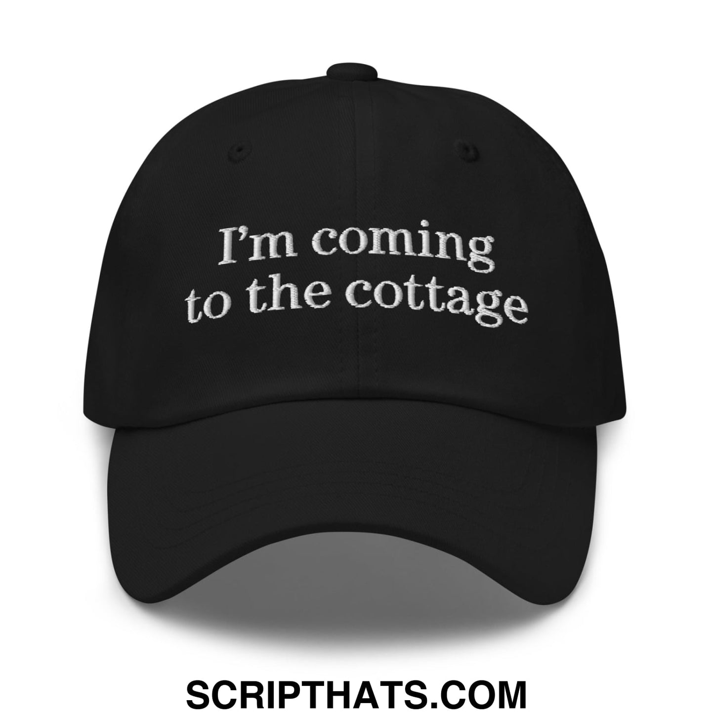 Black unstructured dad hat with white embroidered text im coming to the cottage on the front