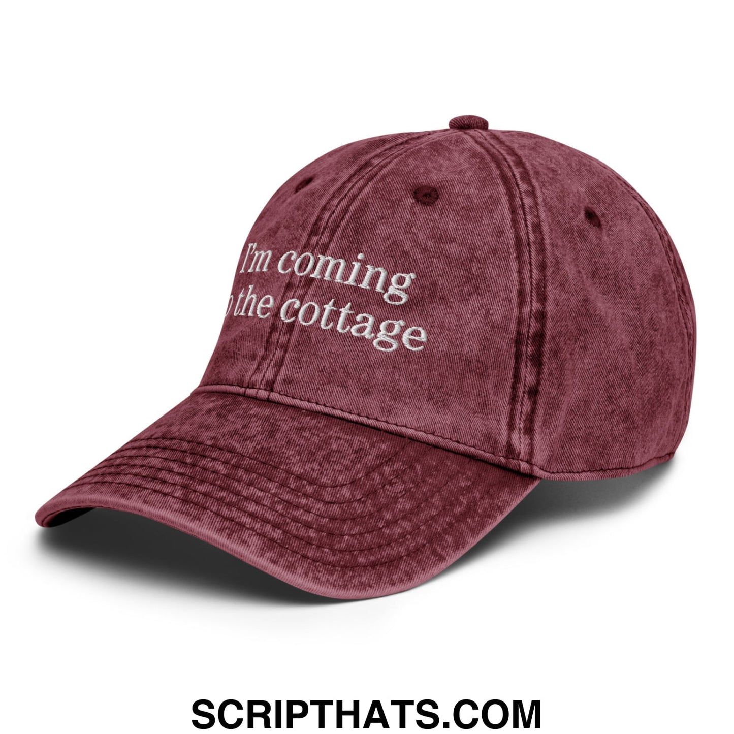 A maroon distressed denim dad hat with white embroidered text saying im coming to the cottage