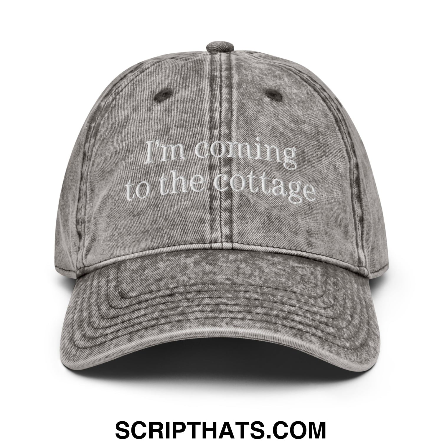 A faded gray unstructured denim dad hat with white embroidered text saying i’m coming to the cottage