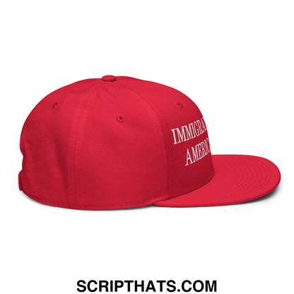 A vibrant red snapback hat with immigrant america embroidered in white script on a flat brim bill