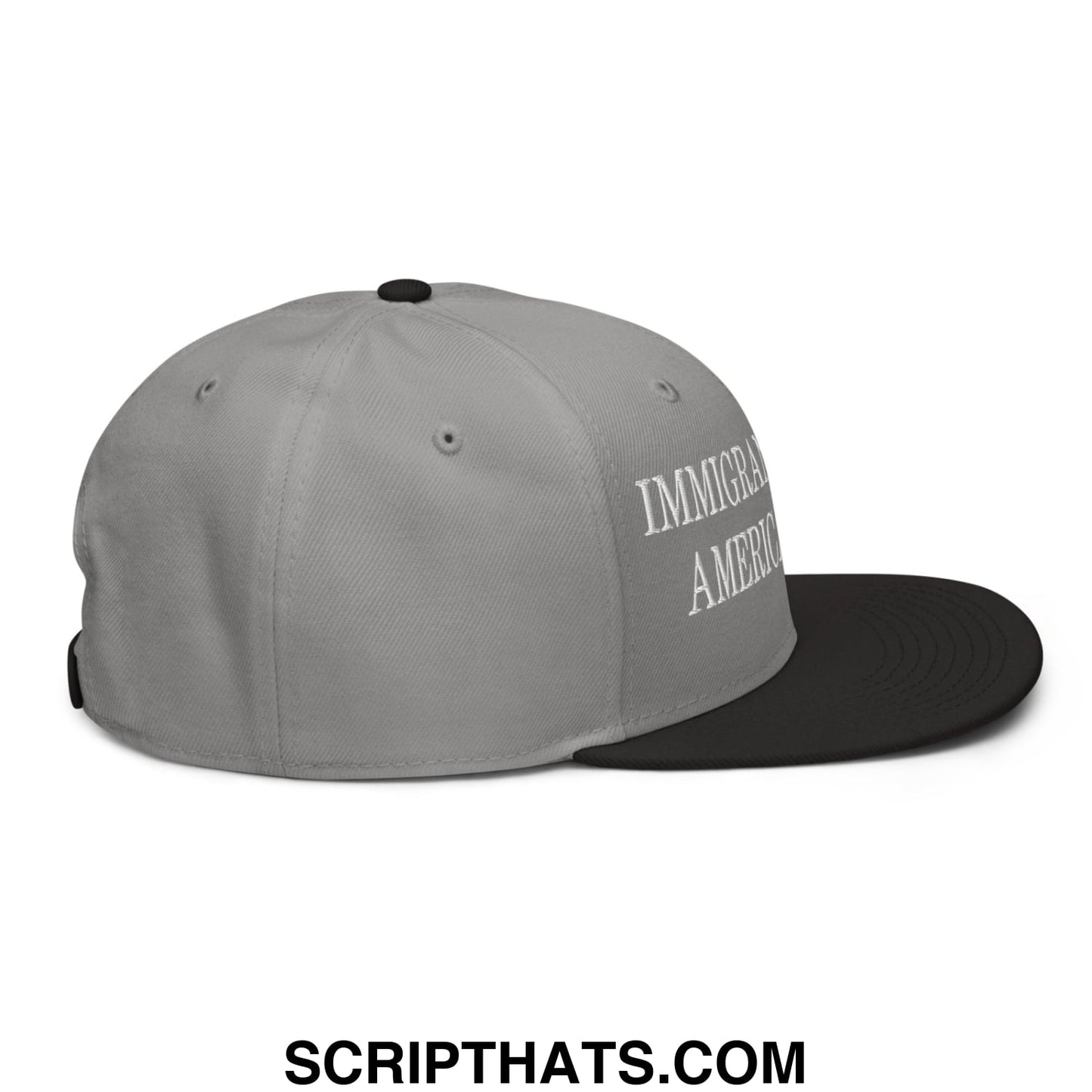 Gray and black snapback cap with immigrant america embroidered in white script on the side in flat brim style
