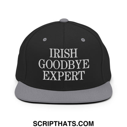 Black snapback cap with gray brim and embroidered white text reading irish goodbye expert flat bill brim hat