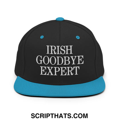 Black snapback hat with teal brim and button featuring white embroidered irish goodbye expert text