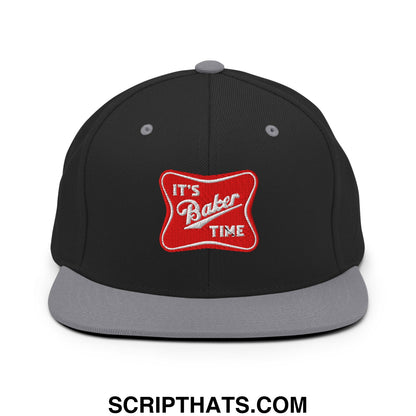 Black snapback hat with gray brim and red patch embroidered with its baker time in white script