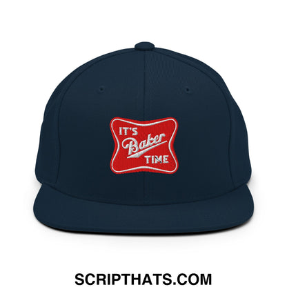 Navy blue snapback cap with flat bill brim featuring a red embroidered patch reading its baker time