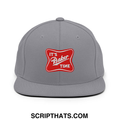 Gray snapback cap with a flat bill featuring a red embroidered patch with white text reading it’s baker time