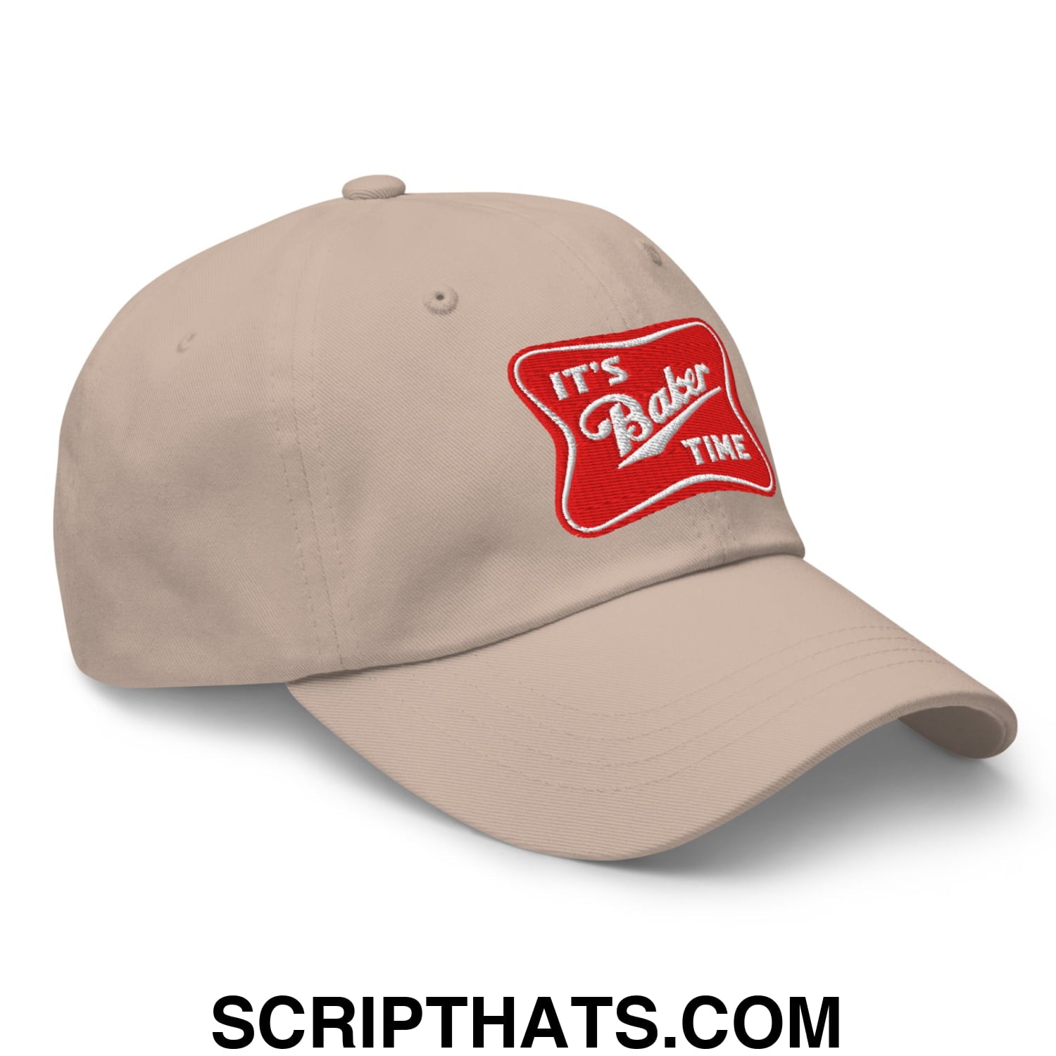 Beige unstructured dad hat featuring a red embroidered patch with white lettering it’s baker time