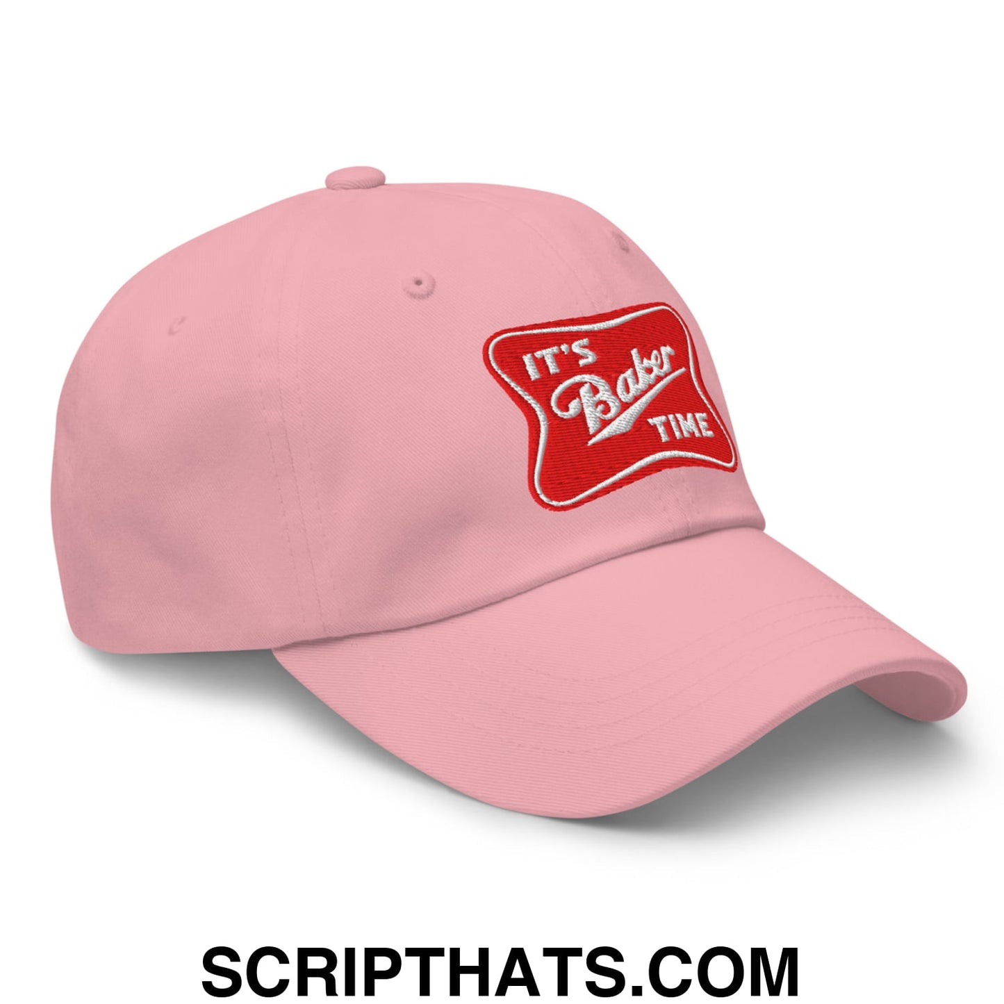 Pink unstructured dad hat with a red embroidered patch reading its baker time in white script