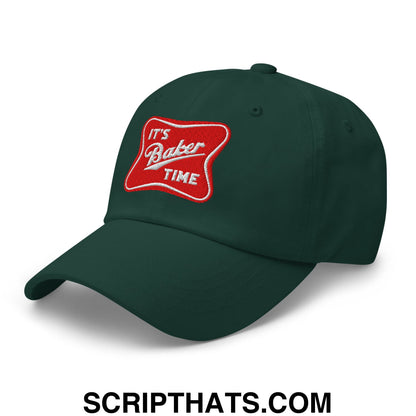 Dark green unstructured dad hat featuring red embroidered patch with white cursive lettering it’s baker time