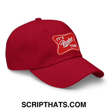 Red unstructured dad hat with a white embroidered patch reading its baker time in script font