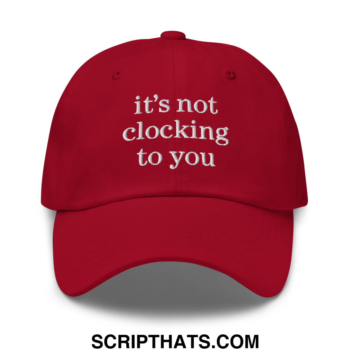 A vibrant red embroidered unstructured dad hat with white text reading its not clocking to you