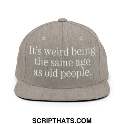 Gray snapback hat with white embroidered text it’s weird being the same age as old people flat bill brim