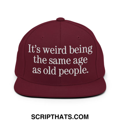 Maroon flat bill brim snapback hat with white embroidered text its weird being the same age as old people