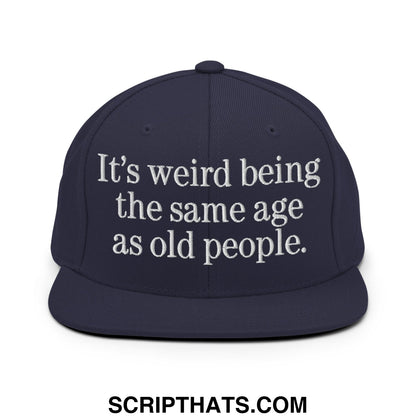 Navy blue snapback hat with white embroidered text it’s weird being the same age as old people flat bill brim