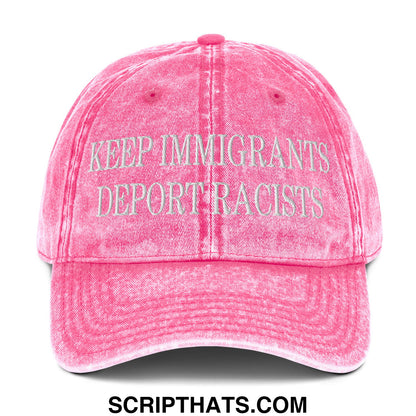 A faded pink denim dad hat with embroidered white text reading keep immigrants deport racists