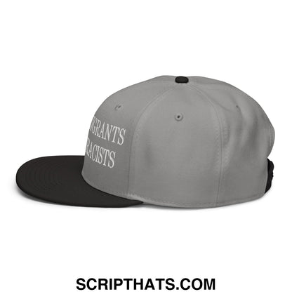 Gray and black snapback hat with white embroidered text reading immigrants not racists on the side