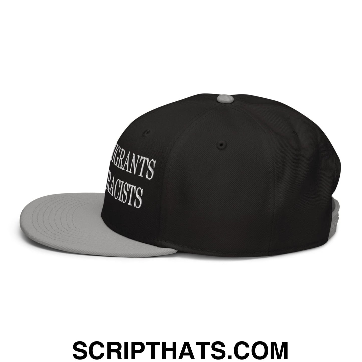 Black and gray snapback cap with flat brim and white embroidered text reading migrants are not racists