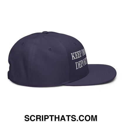 Navy blue snapback hat with white embroidered keep in deport text on the side featuring flat brim design