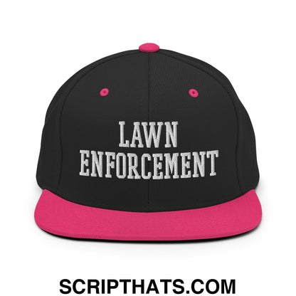 Black snapback hat with pink brim and button featuring lawn enforcement embroidered in white on the front