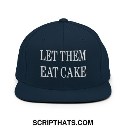 Navy blue snapback cap with white embroidered let them eat cake text and flat bill brim design