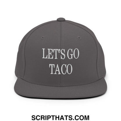 A dark gray snapback hat with flat bill brim featuring lets go taco embroidered in white thread on front panel