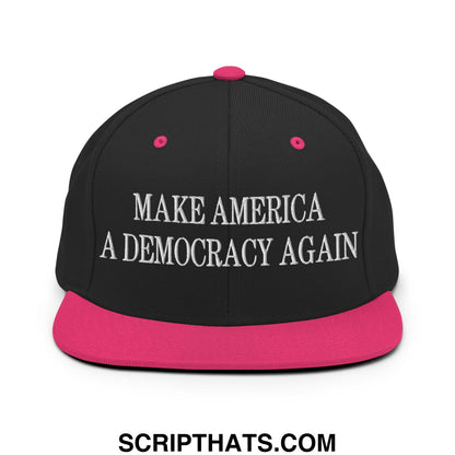 Black snapback cap with vibrant pink brim and button embroidered with make america a democracy again text
