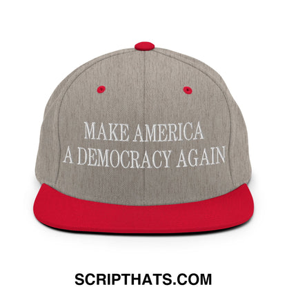 Gray and red snapback cap with white embroidered text make america a democracy again on the front panel